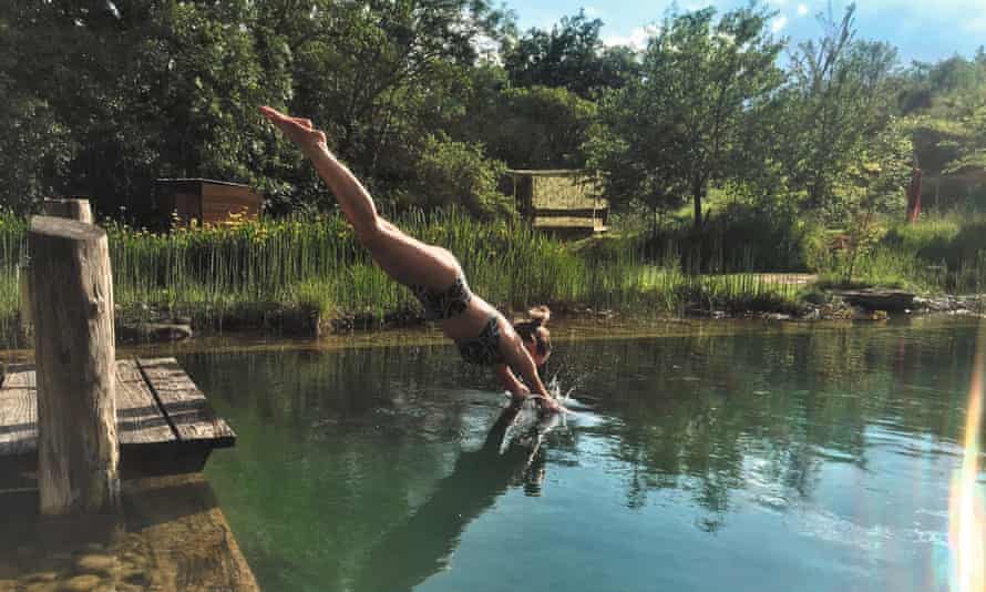 Women in bikini diving into pond