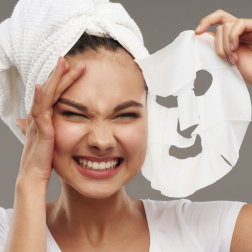 woman peeling off a facemask treatment