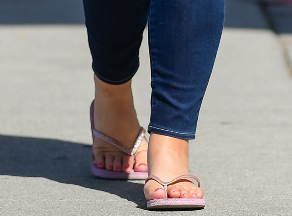 Lana Del Rey wearing light pink rubber flip-flops featuring glittery straps