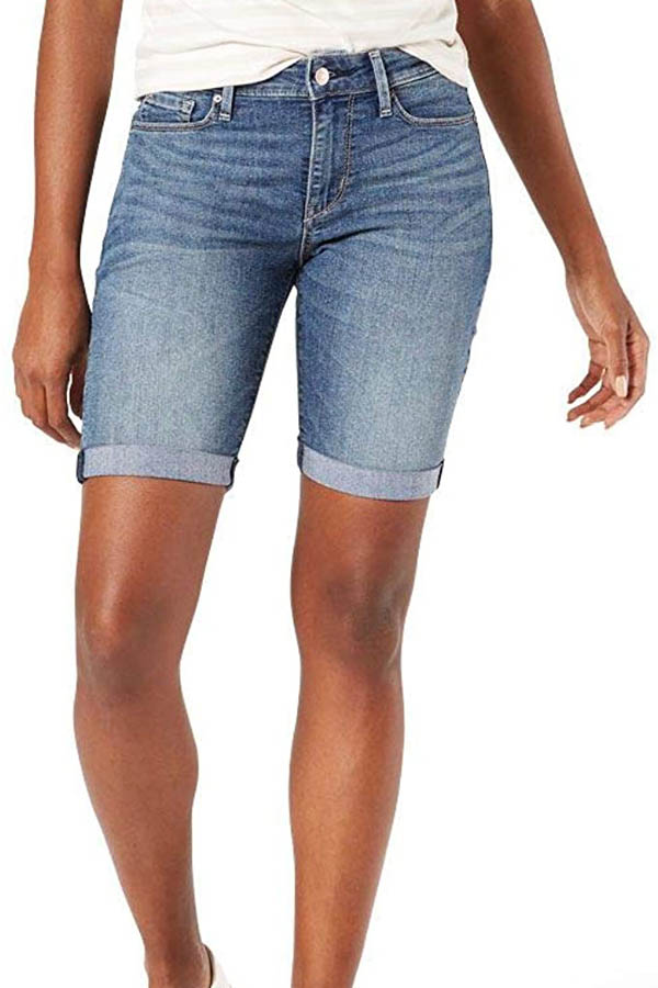 Waist-down view of model wearing denim shorts.