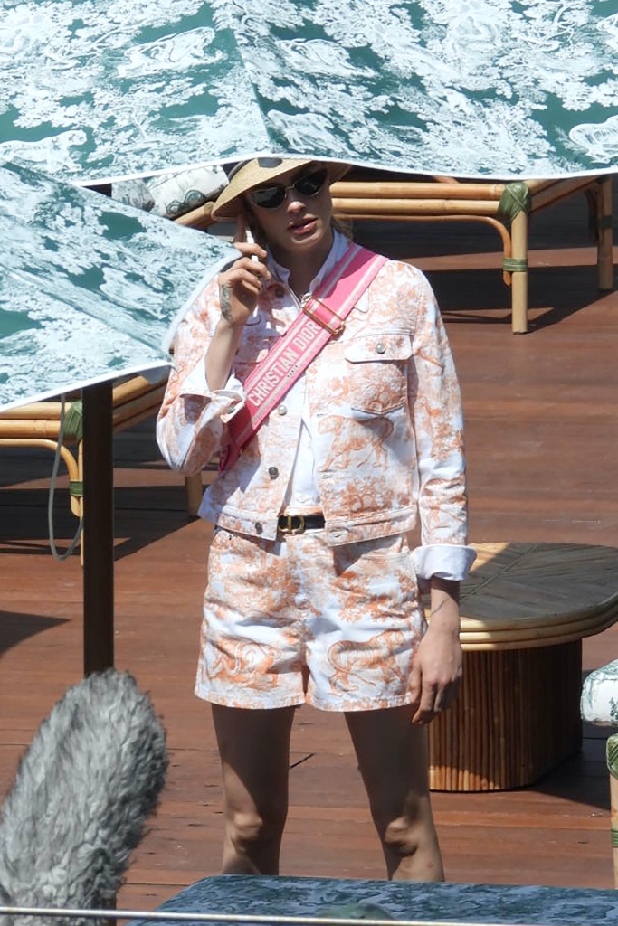 cara Delevigne on set for a Dior campaign on June 7, Cara Delevigne, dior, shoot, beach, orange top