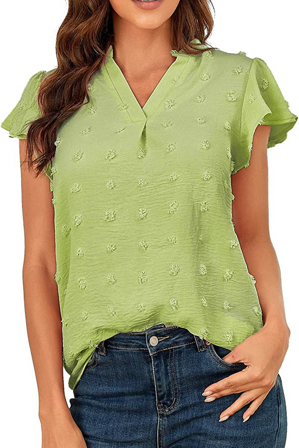 Close-up of model wearing green blouse with textured details.