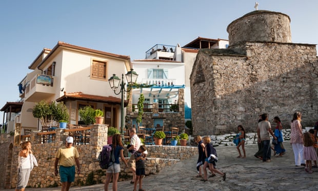 Tourists walk by Church of Christ at the Old Village of Alonnisos