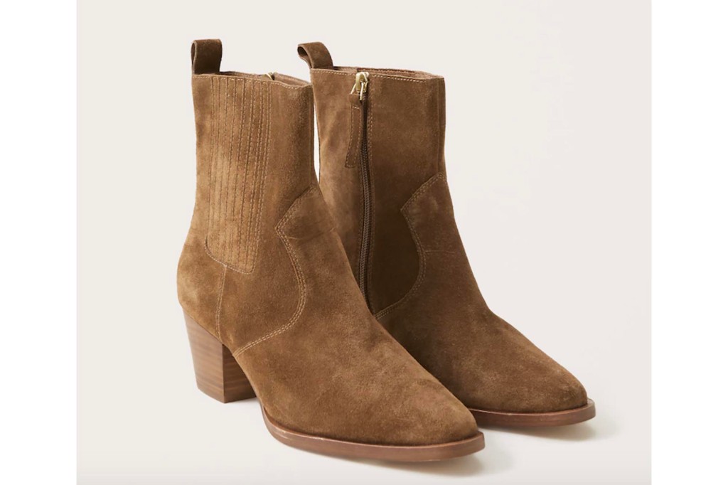 A pair of brown suede booties with a heel 
