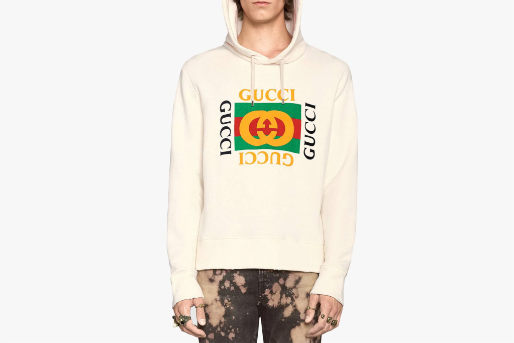 A man in a white Gucci hoodie with green and yellow logo 