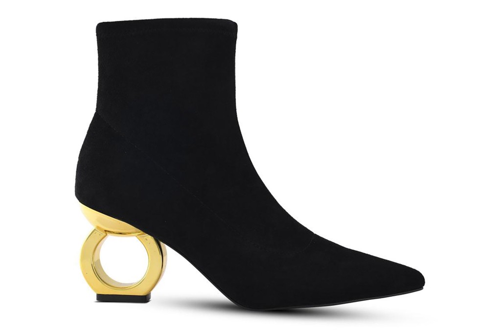 A black bootie with a circular gold heel 