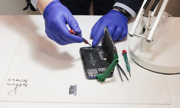 An opened phone is being repaired with special tools