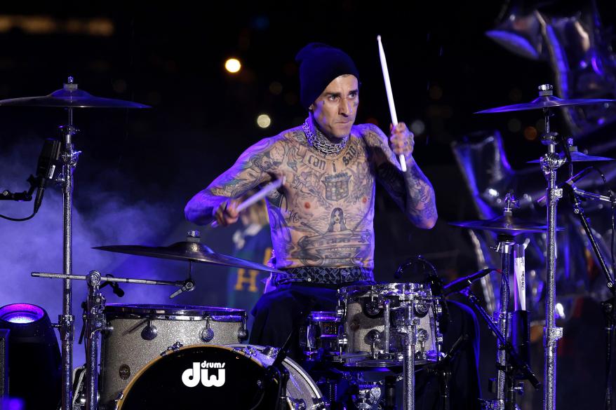 Travis Barker plays drums at the Tommy Hilfiger Fall 2022 collection show.