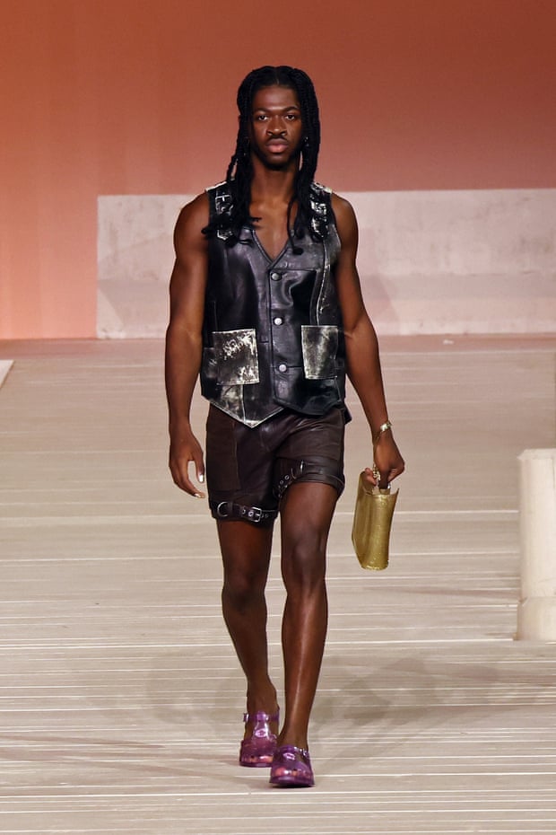 Rapper Lil Nas X wearing a big leather waistcoat and shorts on the Coach runway 