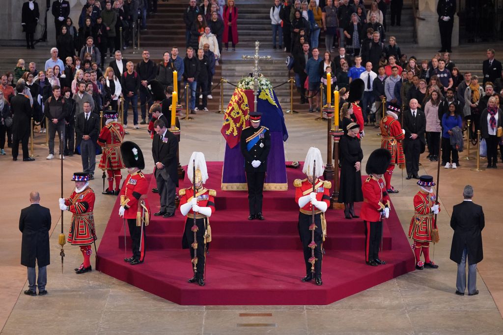 TOPSHOT - Queen Elizabeth II 's grandchildren (clockwise from front centre) Britain's Prince William, Prince of Wales, Peter Phillips, James, Viscount Severn, Britain's Princess Eugenie of York, Britain's Prince Harry, Duke of Sussex, Britain's Princess Beatrice of York, Britain's Lady Louise Windsor and Zara Tindall hold a vigil around the coffin of Queen Elizabeth II, draped in the Royal Standard with the Imperial State Crown and the Sovereign's orb and sceptre, lying in state on the catafalque in Westminster Hall, at the Palace of Westminster in London on September 17, 2022, ahead of her funeral on Monday. - Queen Elizabeth II will lie in state in Westminster Hall inside the Palace of Westminster, until 0530 GMT on September 19, a few hours before her funeral, with huge queues expected to file past her coffin to pay their respects. (Photo by Aaron Chown / POOL / AFP) (Photo by AARON CHOWN/POOL/AFP via Getty Images)