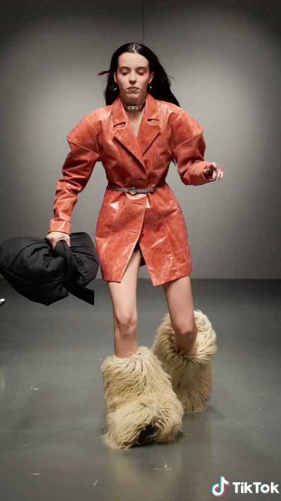 Model in fur boots falling