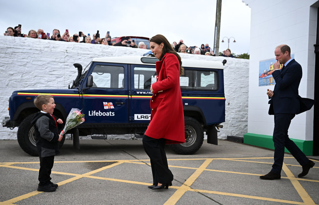 kate middleton, red coat, black pants, black top, boots, Royal National Lifeboat Institution, wales