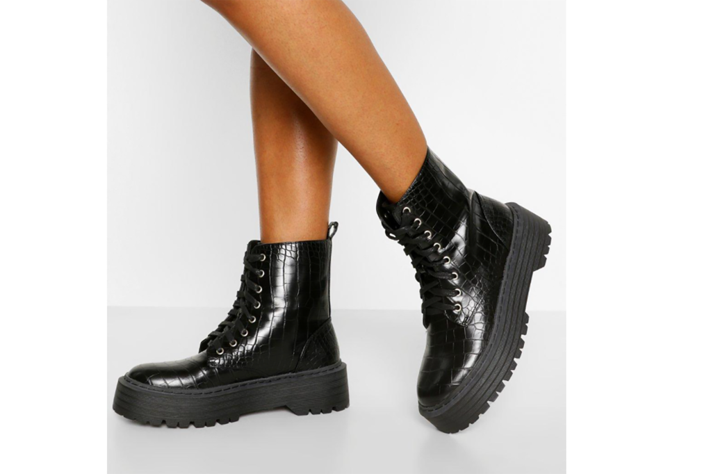 A woman's feet in black croc print combat boots 