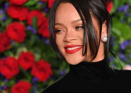 Rihanna smiles in close up in front of flower background