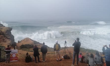 Spectators watch the waves from near Nazare’s lighthouse.