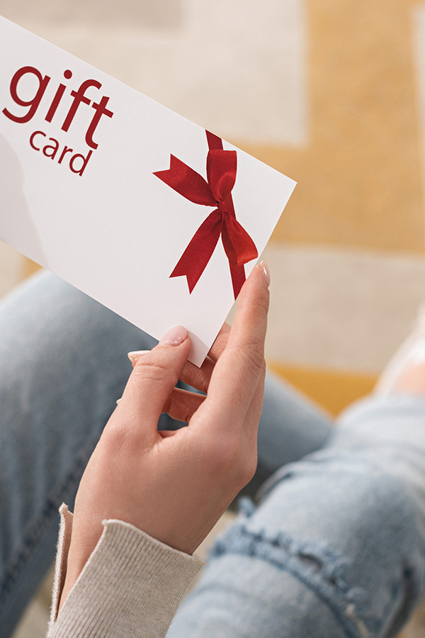 Close up of woman's hands holding a gift card, a practical gift. 