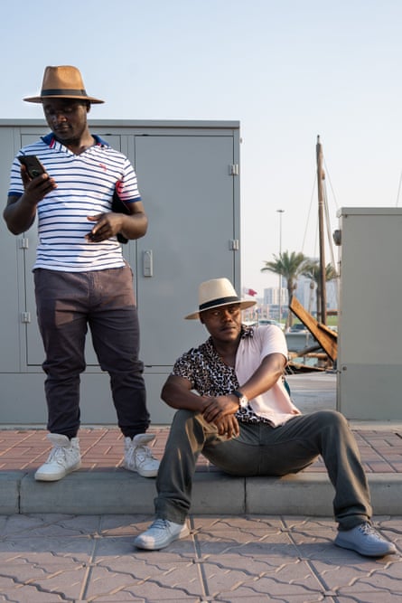 Kennedy, a driver, and Louise, a construction worker from Kenya relaxing by the sea in Doha, Qatar on a sunny day.