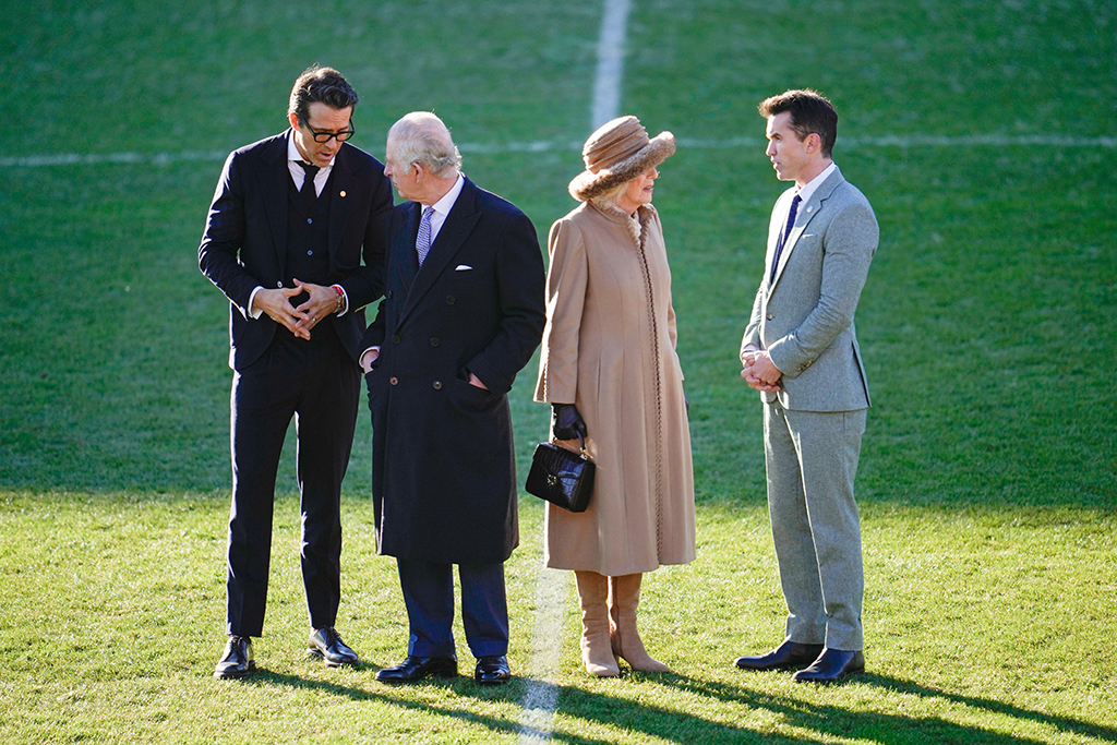 King Charles III and Camilla, Queen Consort talk to Co-Owners Wrexham AFC Ryan Reynolds (L) and Rob McElhenney (R) during their visit to Wrexham AFC on Dec. 9, 2022 in Wrexham, Wales.