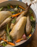 Guinea fowl in a dish with vegetables and sauce.