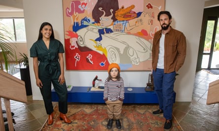 Clarissa and Tim Harris and their child stand in front of the Mlak painting in their home