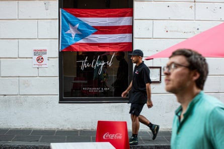 Two men walk past a Puerto Rican poster flag