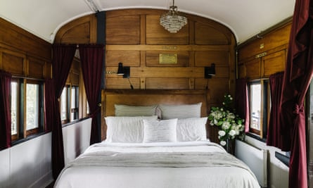 The double bedroom with wood panelling and white linen on the bed