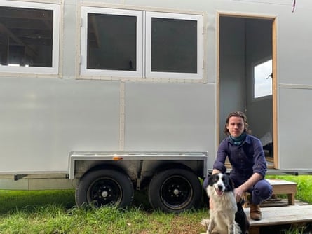 Rio Davis and their dog in front of their tiny house