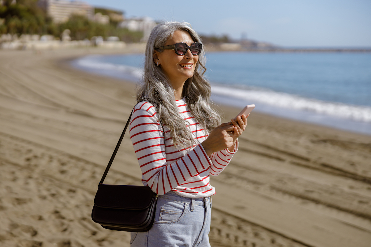 Elegant Asian lady standing outdoors by seafront