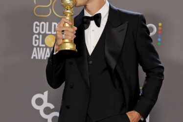 Austin Butler poses with his Golden Globe award for best actor in a motion picture drama.