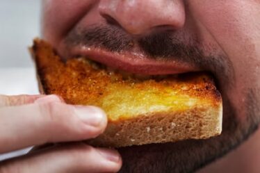 Close-up of man eating toast