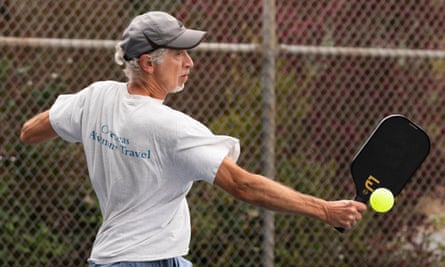 Grey-haired man playing pickleball