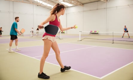 Young woman serving at pickleball