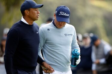 Tiger Woods of the United States  and Justin Thomas of the United States walk off the ninth tee during the first round...