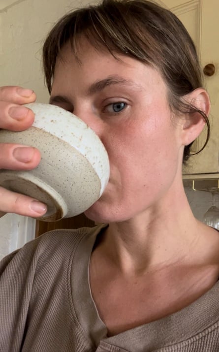A woman drinking from a earthy-coloured clay bowl