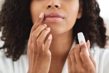 Woman applying moisturizing chapstick on lips