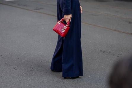 A guest wears navy wide-leg trousers and a red Dior bag outside Bally during the Milan Fashion Week Womenswear Fall/Winter 2023/2024 on February 25, 2023 in Milan, Italy.