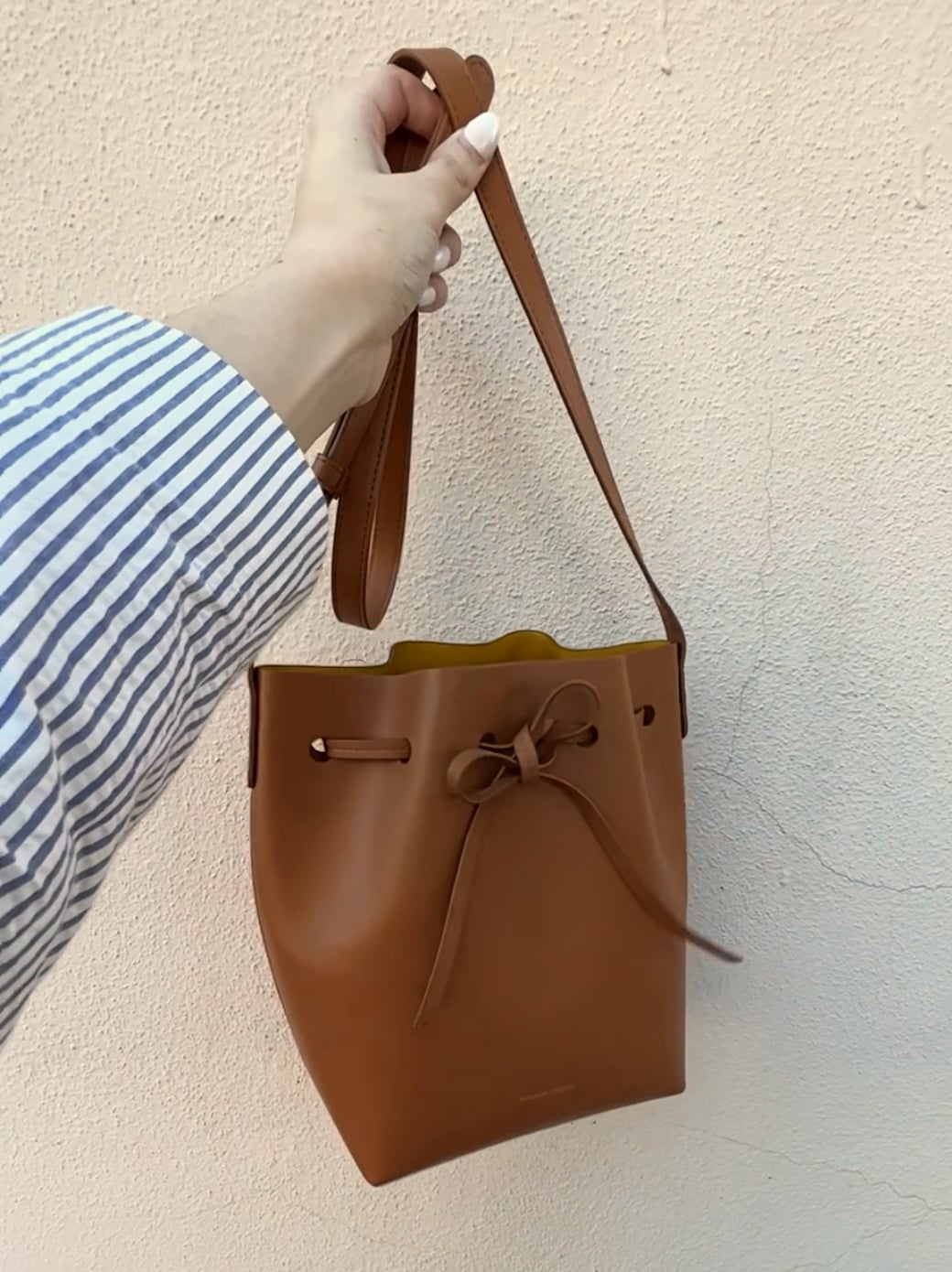 woman carrying Mansur Gavriel Apple Leather Bucket Bag