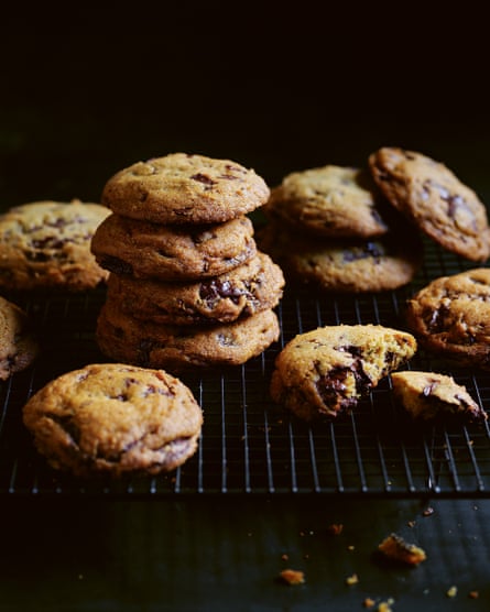 A stack of chocolate chip cookies on a cooling tray. 