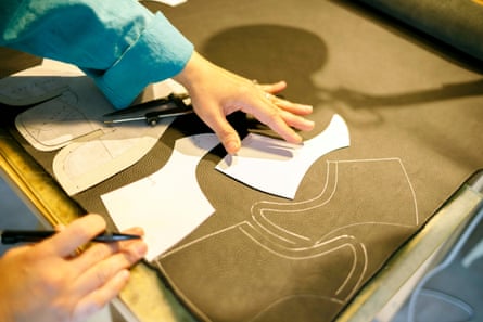 A shoe maker laying out patterns in a studio