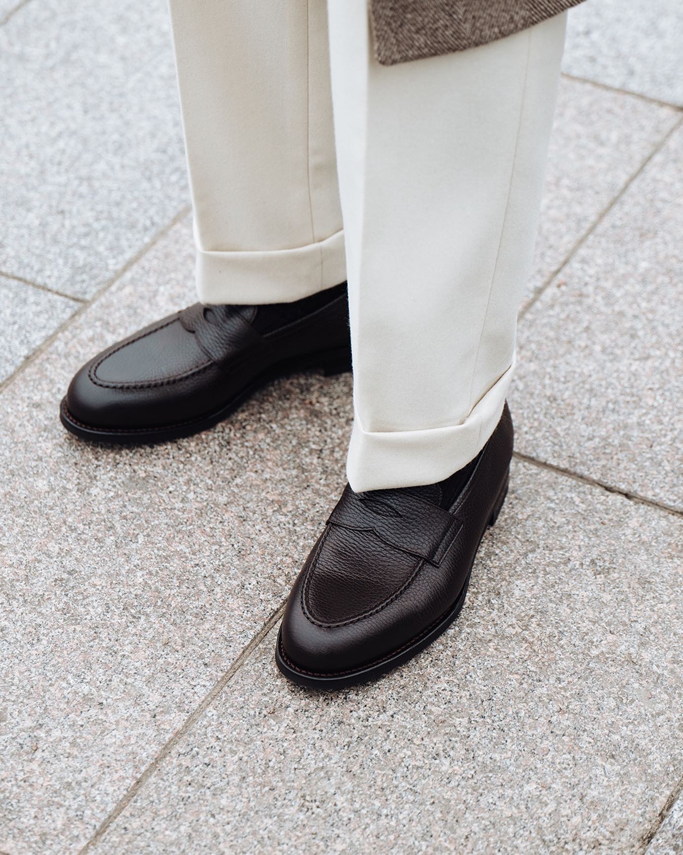 a pair of penny loafer shoes in grain leather