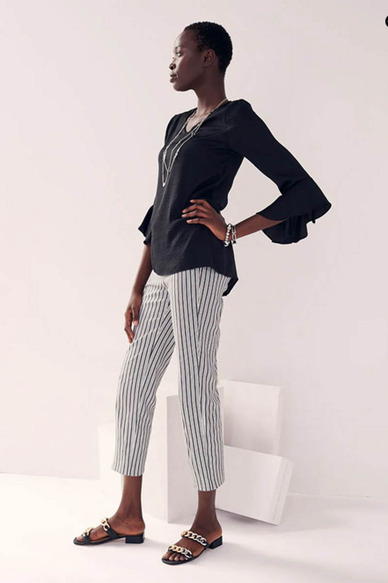 Model wears black top and striped capri pants.