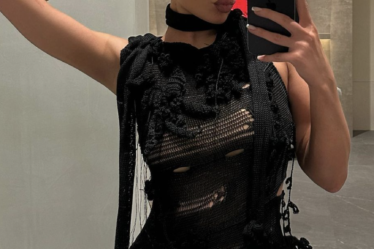 Kylie Jenner taking a mirror selfie in her distressed dress.