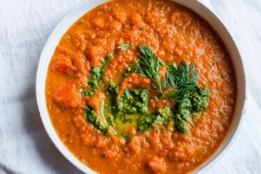 A soup of carrots, dressed with a pesto made from their feathery tops