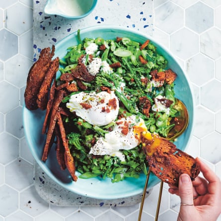 Bright-green broccolini salad topped with breadcrumbs and poached eggs, with large croutons on the side.