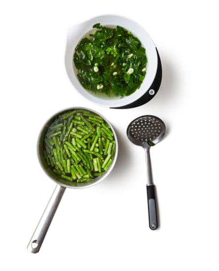 A bowl of spinach and a pan of asparagus. Bring a medium pan of water to a boil and put a colander in a clean sink of cold water (or fill a large bowl with cold water). Snap the woody ends off the asparagus and cut the spears into short lengths. Salt the boiling water, then drop the spinach, beans and peas in the pan, blanch for a minute, then scoop out with a slotted spoon and refresh in the cold water. Cook the asparagus in the same pan for about four minutes, depending on its thickness, until just tender, then add to the rest of the blanched veg.