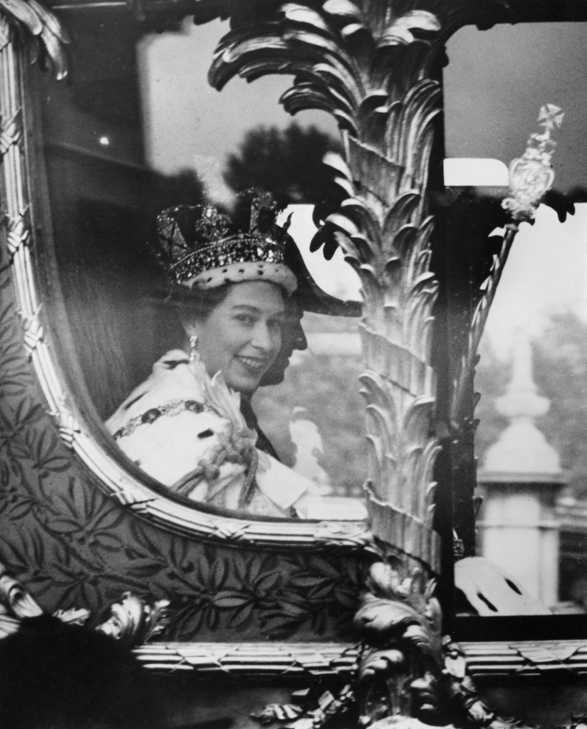 British Royal Elizabeth II, wearing the Imperial State Crown, and her husband, Prince Philip, Duke of Edinburgh, seen through the window of the Gold State Coach as they return to Buckingham Palace during the coronation procession in London, England, 2nd June 1953. The Coronation ceremony took place at Westminster Abbey. (Photo by Illustrated London News/Hulton Archive/Getty Images)
