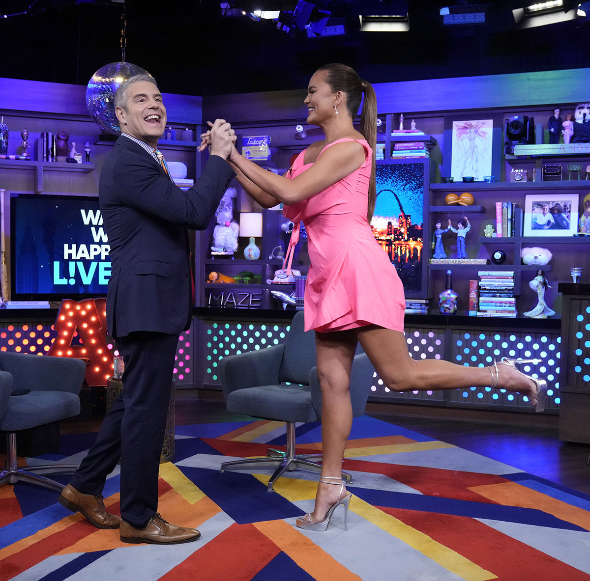 pink vivienne westwood dress, silver high heels, WATCH WHAT HAPPENS LIVE WITH ANDY COHEN -- Episode 20092 -- Pictured: Chrissy Teigen -- (Photo by: Charles Sykes/Bravo via Getty Images), andy cohen