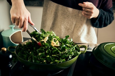 Chopped silverbeet leaves being sauteed in a frying pan. 