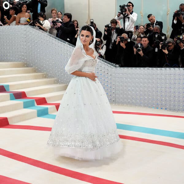 Penélope Cruz in a white dress and a sheer white veil with sparkling details.