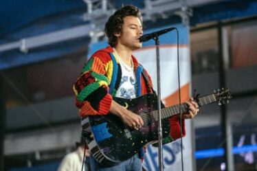 Harry Styles wearing a knitted cardigan while performing on stage